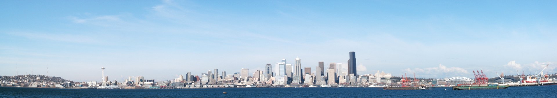 HD desktop wallpaper showcasing the man-made skyline of Seattle against a clear blue sky and waterfront.