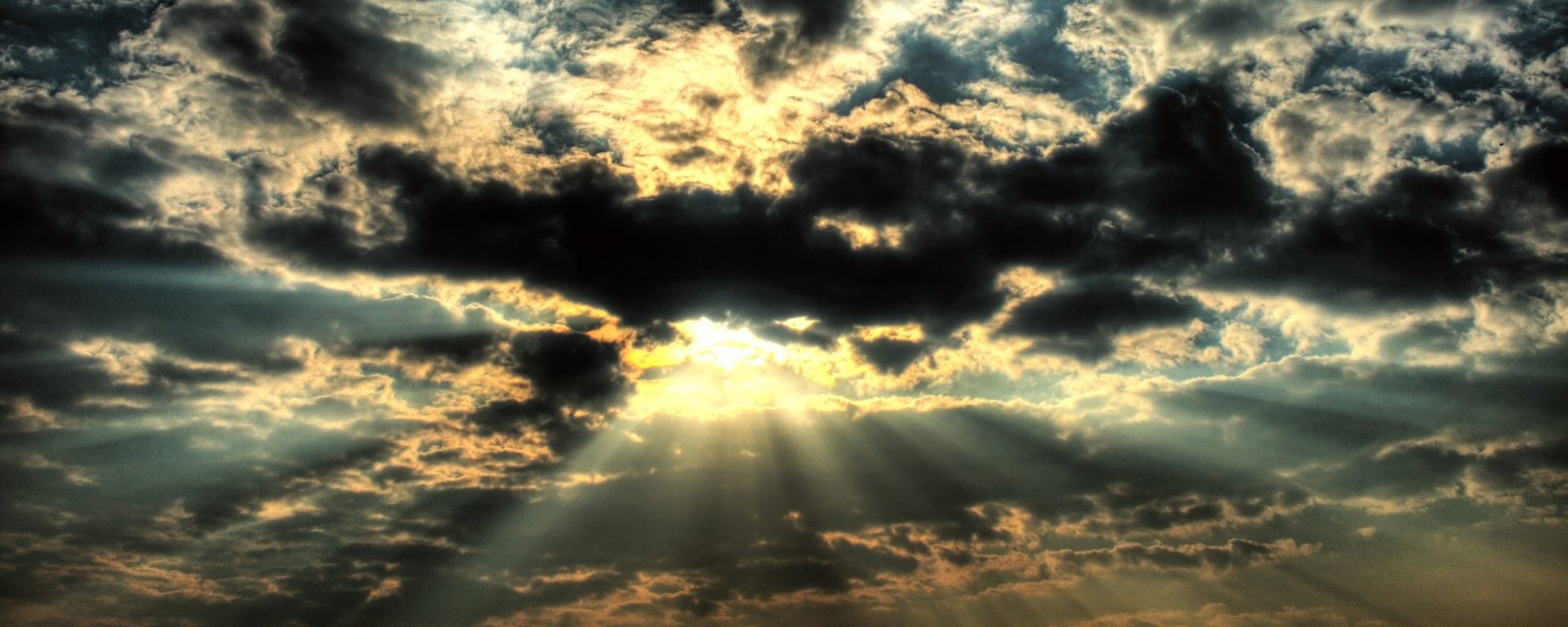 A breathtaking HD image of clouds in a vibrant sky, with sunbeams breaking through, showcasing the beauty of nature. A captivating desktop wallpaper and background.