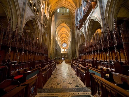 Interior view of Truro Cathedral showcasing its intricate wooden choir stalls and grand arches, captured in high definition for a PC desktop wallpaper.