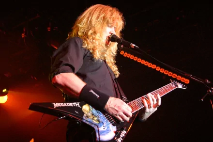 Dave Mustaine performs on stage with his signature guitar, showcasing his powerful presence in the world of Metallica and Megadeth. Dark, energetic atmosphere enhances the musical vibe.