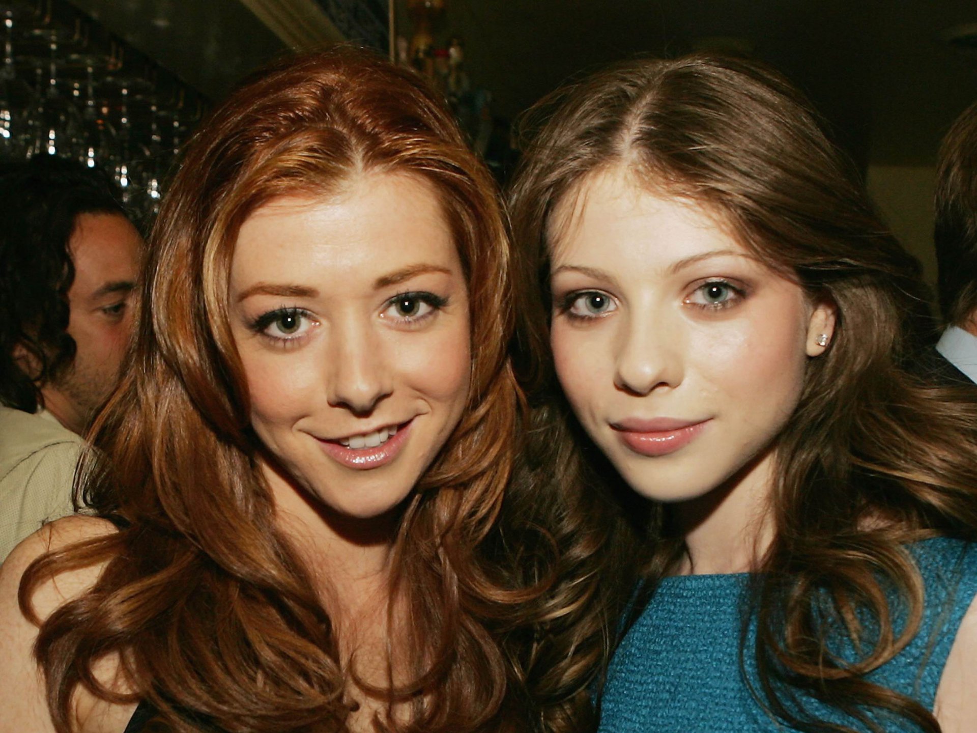 A close-up of celebrities Alyson Hannigan and Michelle Trachtenberg smiling together at an event, showcasing their stylish looks. An HD desktop wallpaper featuring these actors.