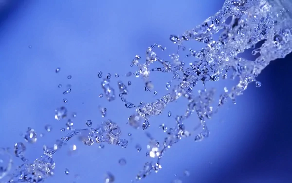 HD desktop wallpaper of water drops captured mid-air against a blue background, showcasing the beauty of nature.