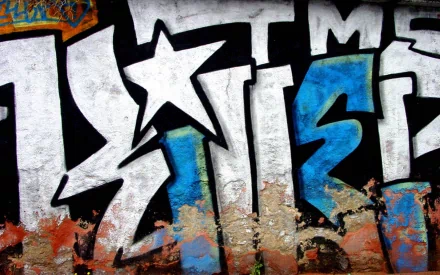 HD desktop wallpaper featuring vibrant graffiti art. The artwork displays bold, stylized letters in white and blue, set against a textured, weathered background with a star symbol.