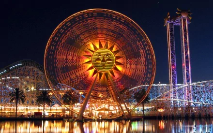 A vibrant nighttime view of Disneyland, featuring a large illuminated Ferris wheel and colorful lights reflecting on the water, capturing the magic of this iconic theme park.
