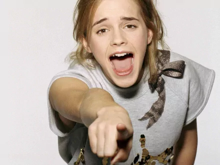 A high-definition desktop wallpaper featuring Emma Watson, who is pointing playfully towards the camera with an open mouth and a joyful expression.