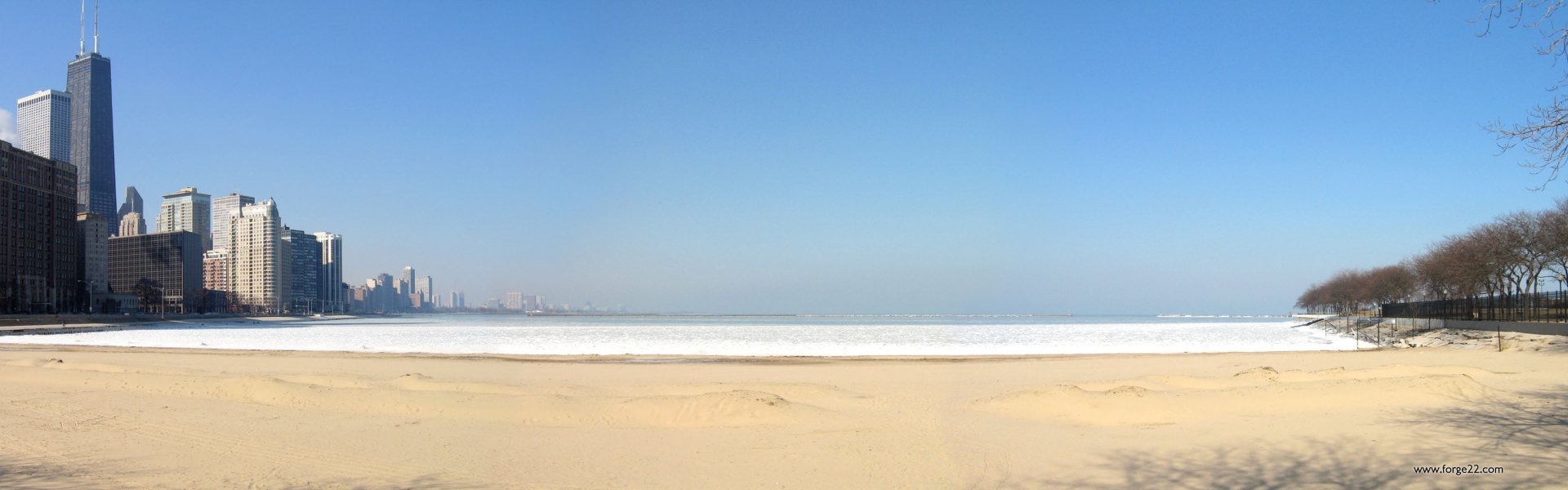 HD PC desktop wallpaper of a serene beach with smooth sand, gentle waves, and a clear blue sky stretching over the horizon, capturing nature's calm beauty.