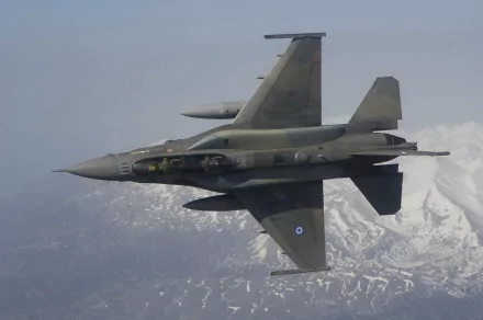 A Greek military General Dynamics F-16 Fighting Falcon jet flies against a backdrop of snow-covered mountains. HD desktop wallpaper and background.