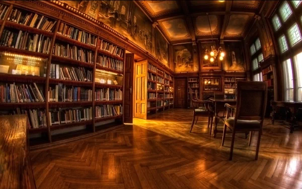 HD wallpaper of an elegant, warm-toned library room with wooden floors, bookshelves, tables, and chairs. The soft sunlight streams through large windows, enhancing the room's inviting ambiance.