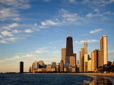 A stunning HD desktop wallpaper showcasing the skyline of Chicago against a vibrant blue sky, featuring iconic skyscrapers alongside the tranquil shoreline.