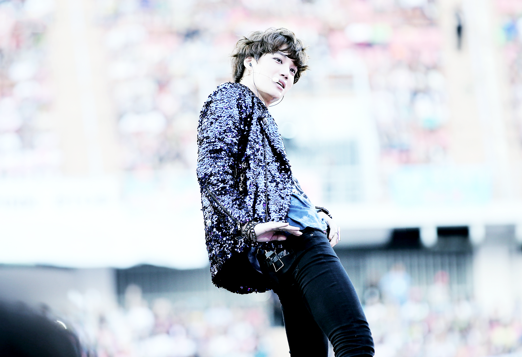 A dynamic HD wallpaper featuring a member of the K-pop group EXO performing on stage, surrounded by an energetic crowd, capturing the essence of live music and fan excitement.