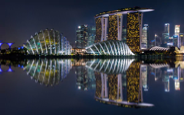 Nighttime reflection of Marina Bay Sands and surrounding illuminated buildings in Singapore, captured in a high-definition wallpaper.