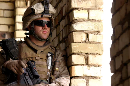 Marine soldier in full military gear, standing guard with rifle during patrol, captured in a high-definition desktop wallpaper background.