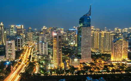A stunning HD view of Jakarta, Indonesia, showcasing a vibrant city skyline illuminated at night, with tall buildings and busy streets, capturing the essence of urban life in Java.