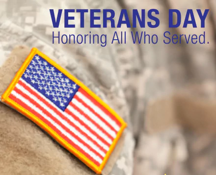 HD desktop wallpaper honoring Veterans Day with a close-up of an American flag patch on military camouflage, featuring the text Veterans Day Honoring All Who Served.
