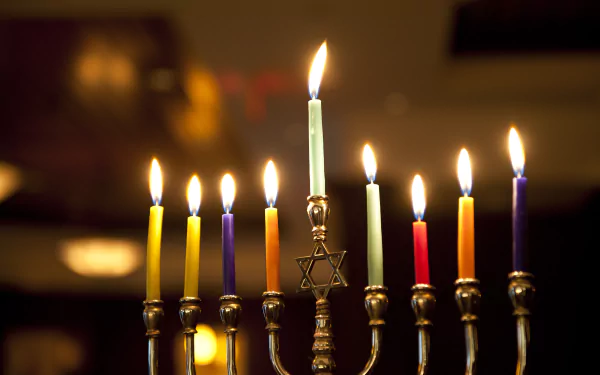 4K Ultra HD desktop wallpaper featuring a brightly lit Hanukkah menorah with colorful candles glowing warmly in a cozy holiday setting.