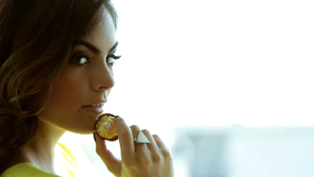 4K desktop wallpaper: close-up of a brunette woman with refined makeup, holding a statement ring to her lips, gazing over her shoulder into a soft, bright backlit background.