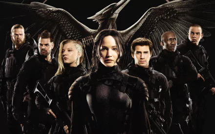 A dramatic HD wallpaper from The Hunger Games: Mockingjay - Part 1, featuring a group of heroes standing strong against a striking black background with a prominent symbol of rebellion overhead.