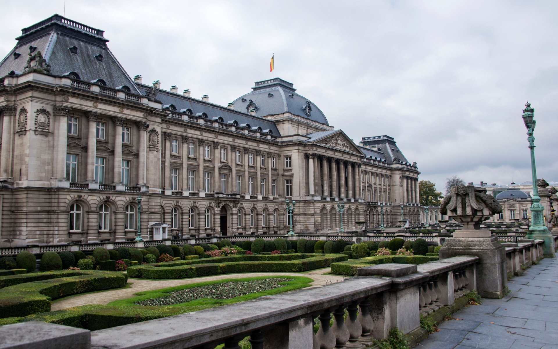 HD desktop wallpaper showcasing the Royal Palace of Brussels, a grand man-made architectural landmark under a cloudy sky.