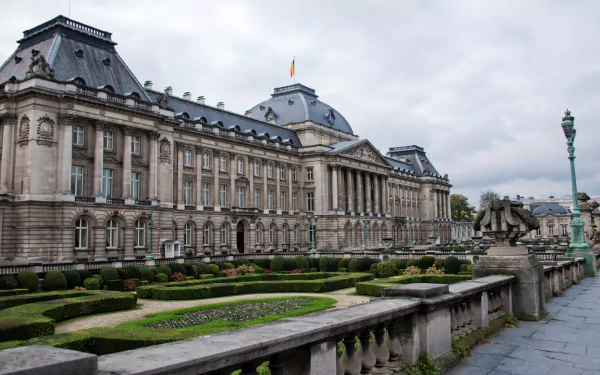 HD desktop wallpaper showcasing the Royal Palace of Brussels, a grand man-made architectural landmark under a cloudy sky.