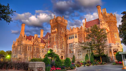 HD PC desktop wallpaper/background: Casa Loma, a man-made stone castle with turrets, towers and landscaped gardens glowing under a dramatic cloudy evening sky.