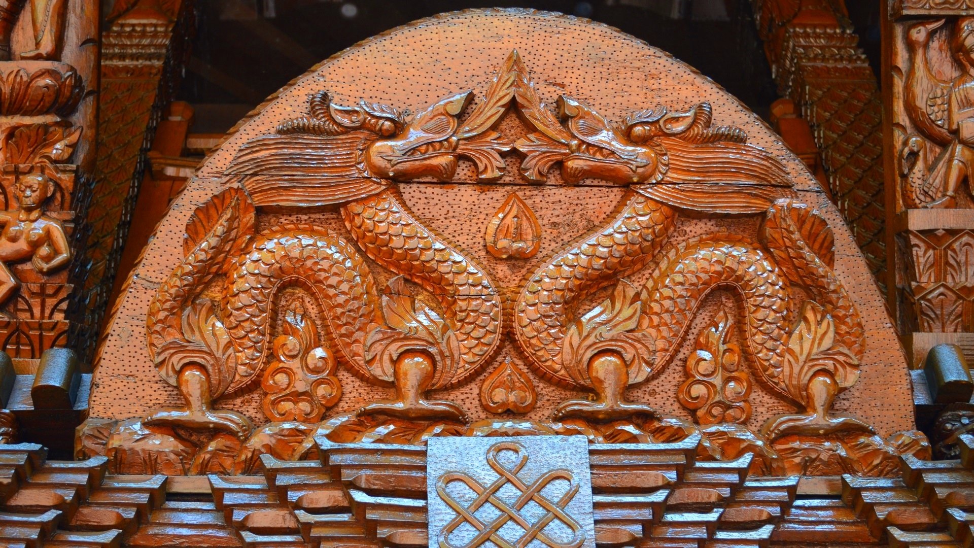 Intricate wood carving of two dragons on a Nepalese pagoda in Brisbane, showcasing traditional craftsmanship in this HD photography background.