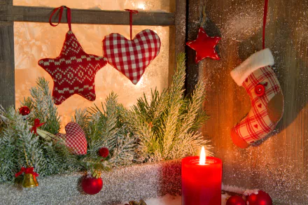 A warm holiday scene featuring a red candle surrounded by festive Christmas ornaments, including stars and hearts, alongside greenery, creating a cozy Christmas atmosphere.