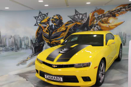 HD desktop wallpaper featuring Bumblebee from Transformers in the background and a vibrant yellow Chevrolet Camaro in the foreground.