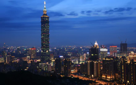 Night cityscape of Taipei with illuminated Taipei 101 tower rising above downtown, 5K Ultra HD PC desktop wallpaper showcasing Taipei's man-made skyline at dusk.