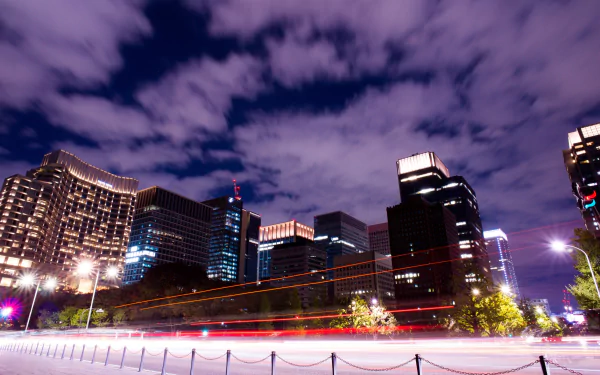 Tokyo cityscape at night showcases Japan's vibrant man-made skyline under a dramatic sky, captured in stunning 4K Ultra HD for a PC desktop background.