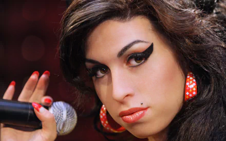 Close-up of an English singer with dramatic winged eyeliner and beehive-style hair holding a microphone; music-themed 2K Quad HD PC desktop wallpaper and background.