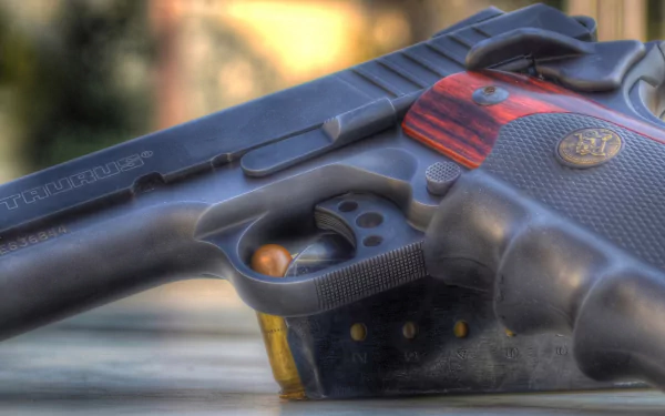 HD PC desktop wallpaper: close-up of a man-made Taurus pistol with wood-accented grip and visible brass cartridges against a soft, blurred background.