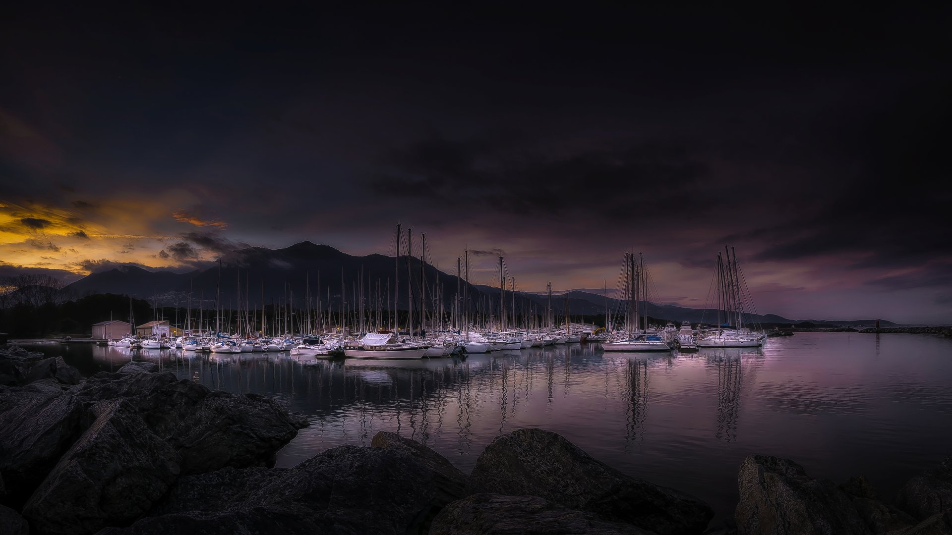 4K Ultra HD PC desktop wallpaper: a man-made harbor at dusk with moored sailboats and masts reflecting on calm water beneath a moody twilight sky.