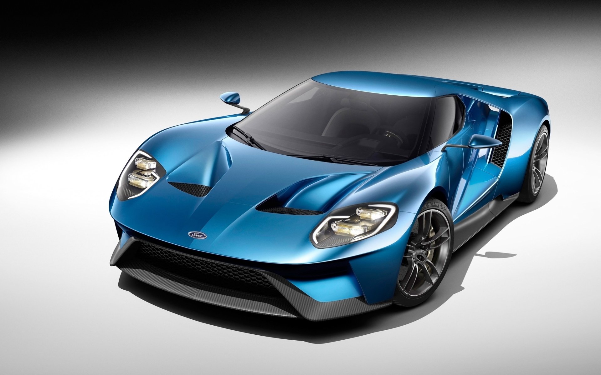 HD PC desktop wallpaper featuring a sleek blue Ford GT sports car with dynamic lighting and a modern, aerodynamic design.
