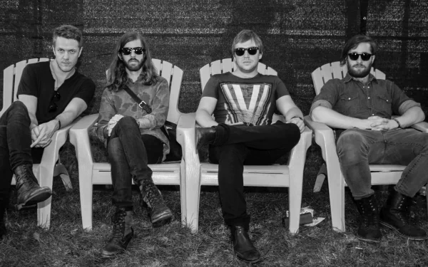 Image of the alternative American band Imagine Dragons, seated casually in Adirondack chairs, exuding a relaxed vibe in black and white. A striking HD desktop wallpaper for music fans.