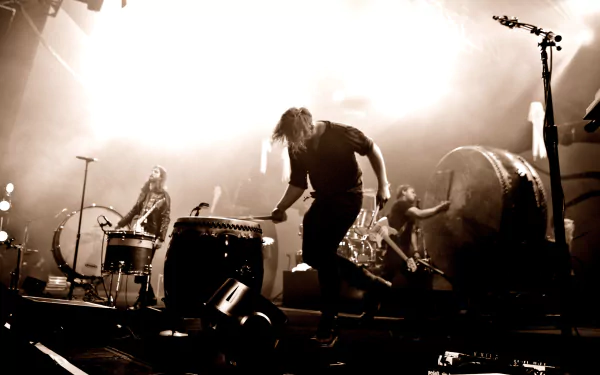 A dynamic performance by the American alternative band Imagine Dragons, showcasing band members passionately playing drums amid dramatic lighting, captured in striking 4K Ultra HD quality.