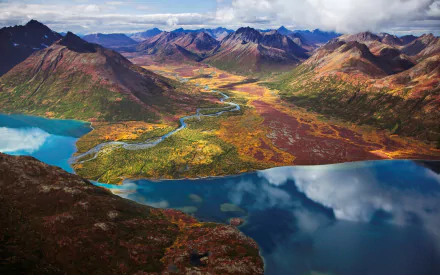 HD wallpaper of a majestic mountain landscape with vibrant autumn colors, reflecting lakes, and a meandering river.