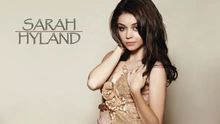 HD desktop wallpaper featuring a poised individual with text Sarah Hyland on a beige background.