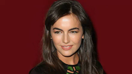 HD close-up wallpaper of a smiling woman with long dark hair, tagged as Celebrity Camilla Belle, against a deep red background.