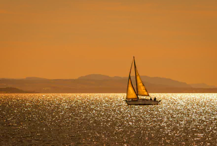 Sailboat boat/vehicle glides across a glittering orange sea at sunset, distant hills on the horizon — HD PC desktop wallpaper and background.