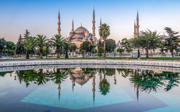 HD desktop wallpaper of the Sultan Ahmed Mosque in Istanbul, Turkey, showcasing its majestic domes and minarets reflected in a tranquil pool.