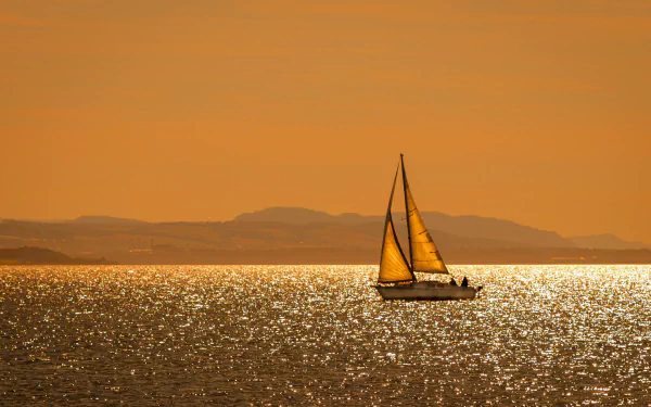 Sailboat boat/vehicle glides across a glittering orange sea at sunset, distant hills on the horizon — HD PC desktop wallpaper and background.