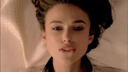 A striking HD wallpaper featuring celebrity Keira Knightley, capturing her serene expression with gently tousled hair against a soft background.