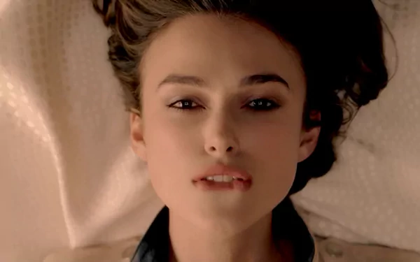 A striking HD wallpaper featuring celebrity Keira Knightley, capturing her serene expression with gently tousled hair against a soft background.