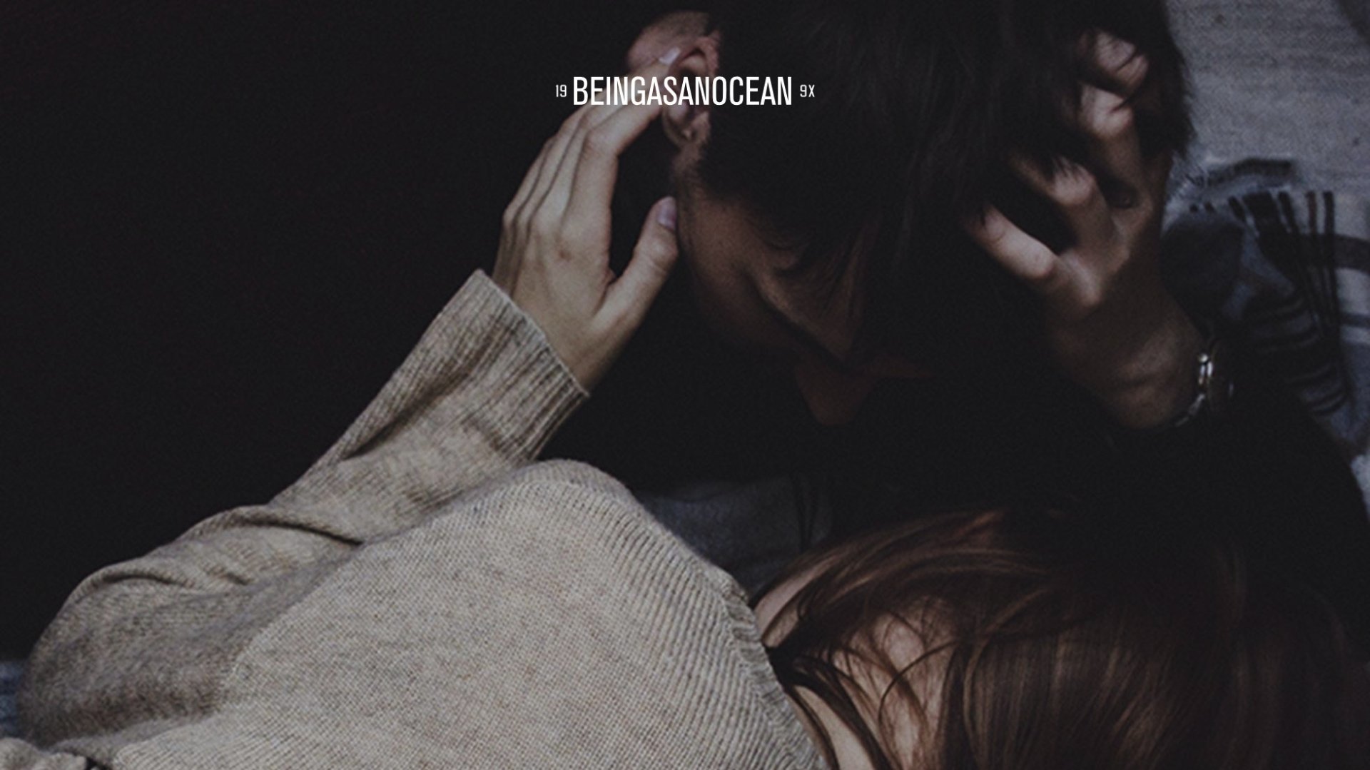 HD desktop wallpaper featuring a close-up of two people embracing with the text Being As An Ocean.