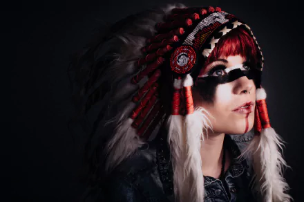 A Native American woman wearing a traditional feathered headdress with red and white accents, set against a dark background in 4K Ultra HD.