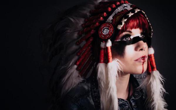 A Native American woman wearing a traditional feathered headdress with red and white accents, set against a dark background in 4K Ultra HD.