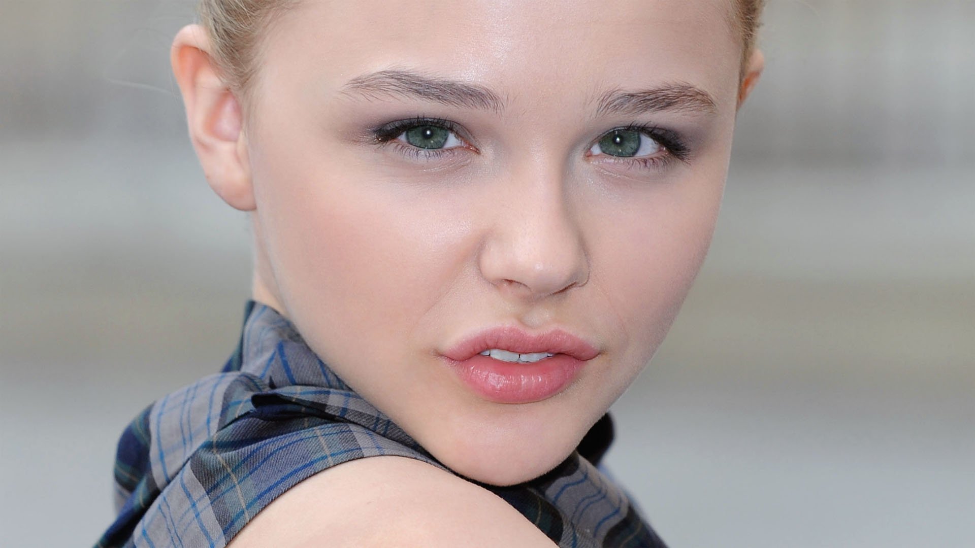 Portrait of Chloë Grace Moretz, capturing her striking features with a focused expression, designed as a high-definition wallpaper for PC desktops.