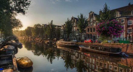 HD desktop wallpaper of Amsterdam's tranquil canal at sunrise, featuring moored boats, reflective water, and classic Dutch architecture. Tags include: reflection, boat, canal, Netherlands, man made.