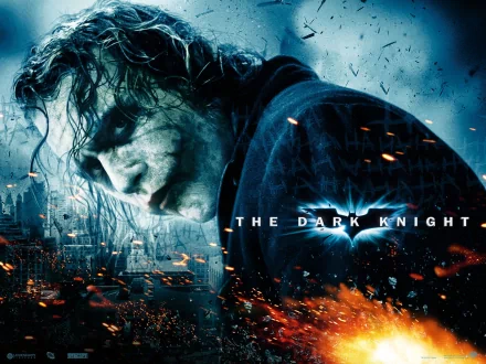 HD desktop wallpaper featuring the Joker from the movie The Dark Knight. The background includes dark tones with flames and debris, embodying the film's intense atmosphere.