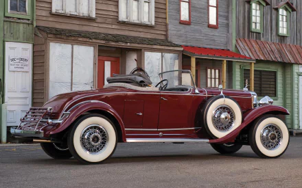 HD desktop wallpaper featuring a maroon 1931 Cadillac convertible parked in front of vintage wooden buildings.